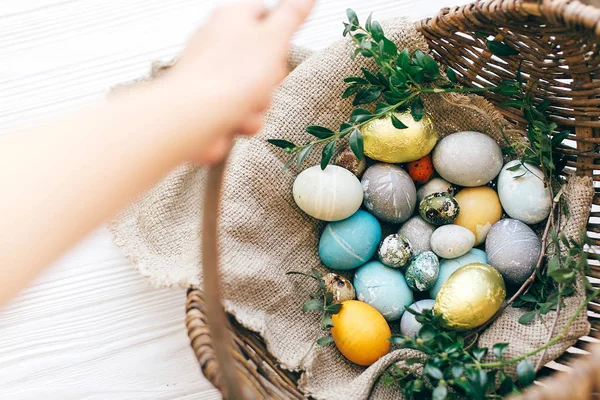 Cesta de mimbre rústica de mano con elegantes huevos de Pascua con — Foto de Stock