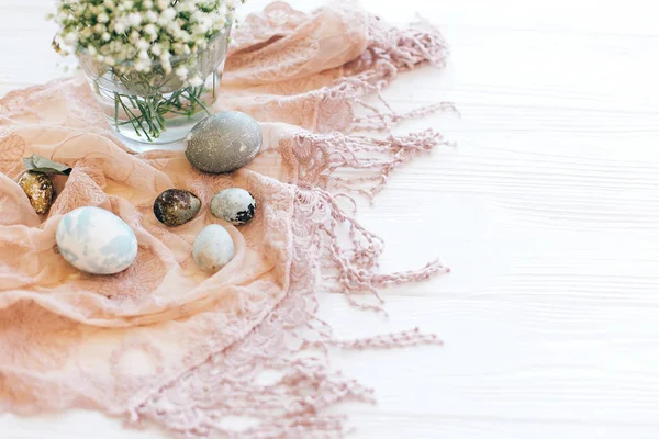 Œufs de Pâques élégants sur tissu rustique avec fleurs de printemps et euc — Photo