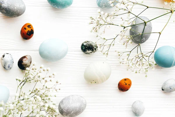 Stylish Easter eggs with spring flowers flat lay on white wooden — Stock Photo, Image