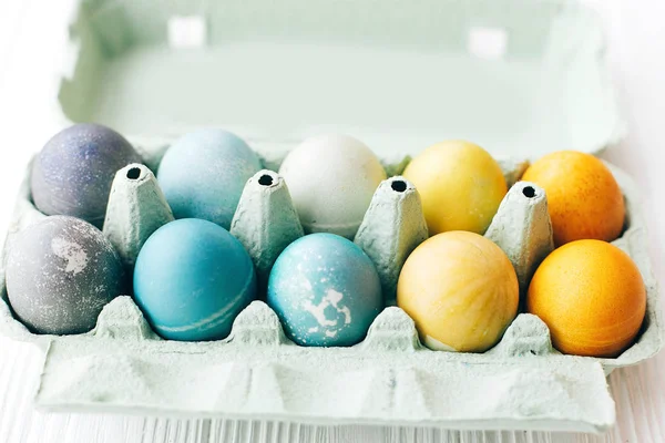 Eleganti uova di Pasqua in vassoio di cartone su sfondo di legno bianco, s — Foto Stock