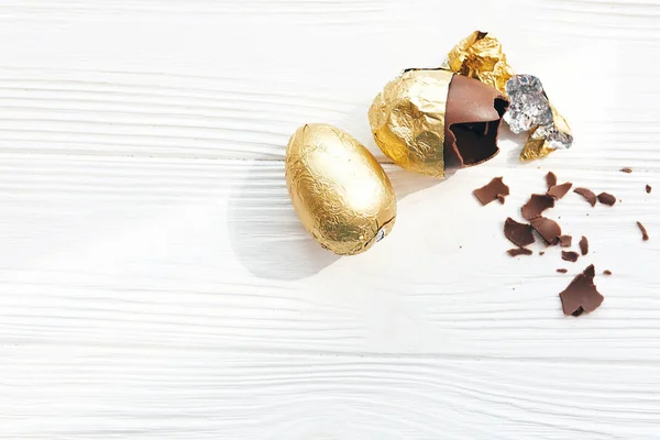 Pisanka stylowe w złotej folii i złamane czekoladowe jajko z — Zdjęcie stockowe