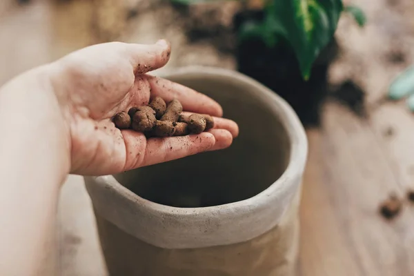 Tangan kotor memegang drainase di pot baru kosong dan berkebun stil — Stok Foto