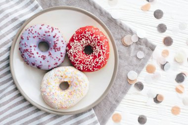 WHI üzerinde şık plaka üzerinde sprinkles ile lezzetli renkli donut
