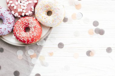 WHI üzerinde şık plaka üzerinde sprinkles ile lezzetli renkli donut