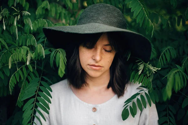 Fille élégante en robe de lin posant sur les branches vertes. Portrait o — Photo