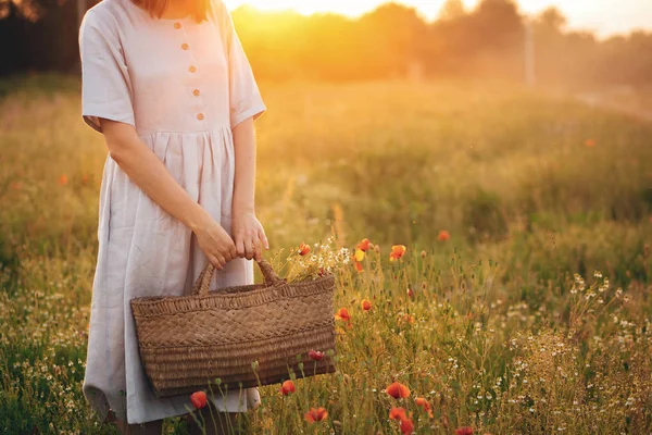 Stylish girl in linen dress holding rustic straw basket with pop — Stock Photo, Image