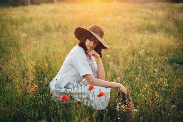 Gün batımı li haşhaş çayır oturan keten elbiseli şık kız — Stok fotoğraf