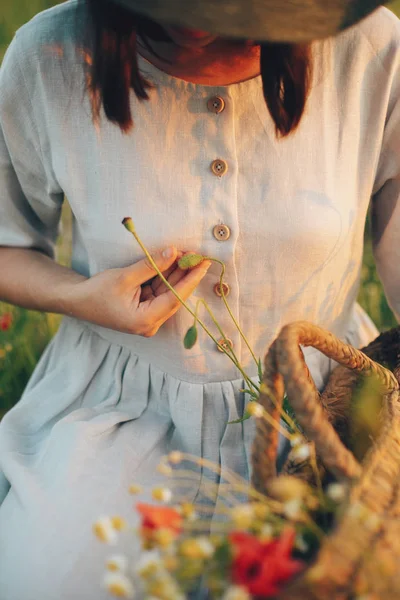Elegáns lány vászon ruhát összegyűjtése rusztikus szalma ba virágok — Stock Fotó