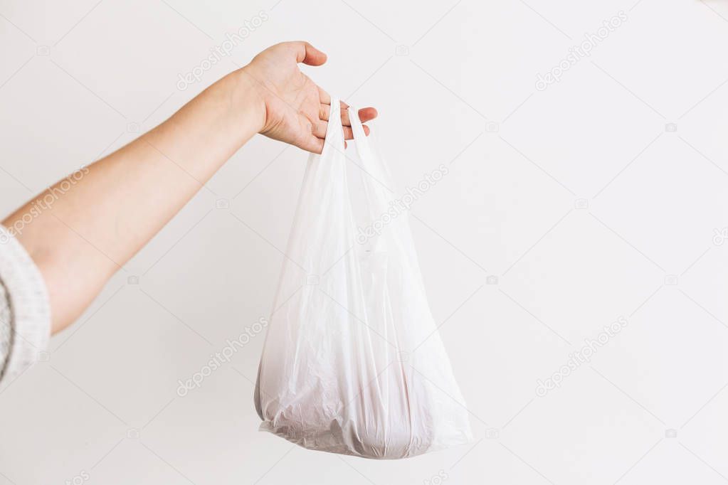 Ban single use plastic. Woman holding in hand groceries in plast