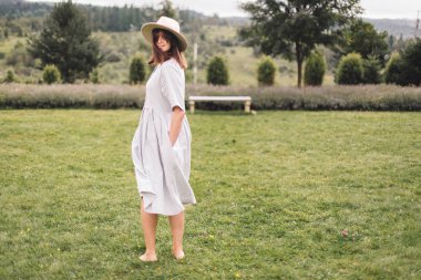 Keten elbise ve şapkalı şık hipster kız lavend eğlenmek