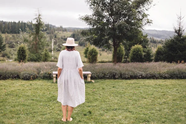 Élégante fille hipster en robe de lin et chapeau debout à la lavande — Photo