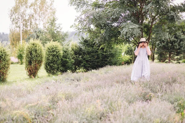 Stijlvolle hipster meisje in linnen jurk en hoed ontspannen in lavendel — Stockfoto