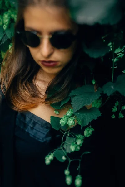 Elegante chica hipster posando en el arbusto de lúpulo verde, momentos atmosféricos —  Fotos de Stock