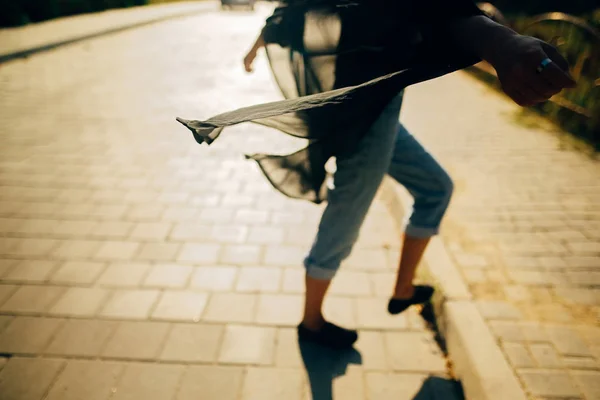 Stijlvolle hipster meisje wandelen in zonnig licht in straat, sfeer — Stockfoto