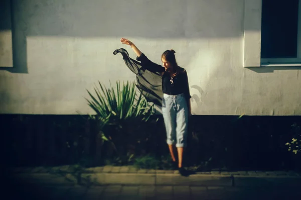 Stijlvolle hipster meisje poseren in zonnig licht in straat, sfeervol — Stockfoto