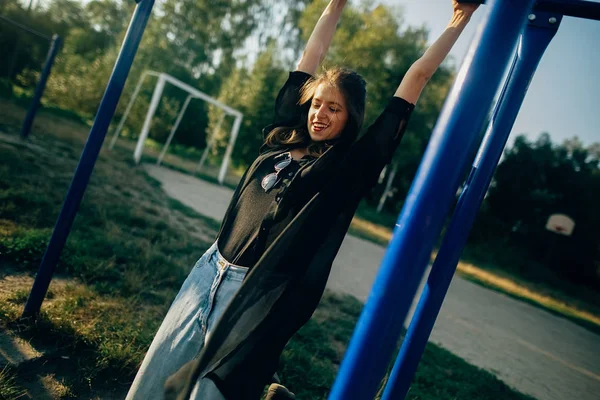 Stylisches Hipster-Mädchen, das Spaß auf dem Spielplatz in der sonnigen Straße hat, ein — Stockfoto