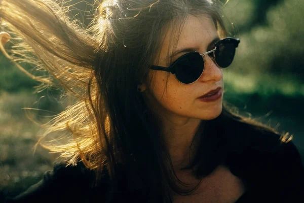 Elegante ragazza hipster in posa nel parco soleggiato con incredibili raggi di sole — Foto Stock