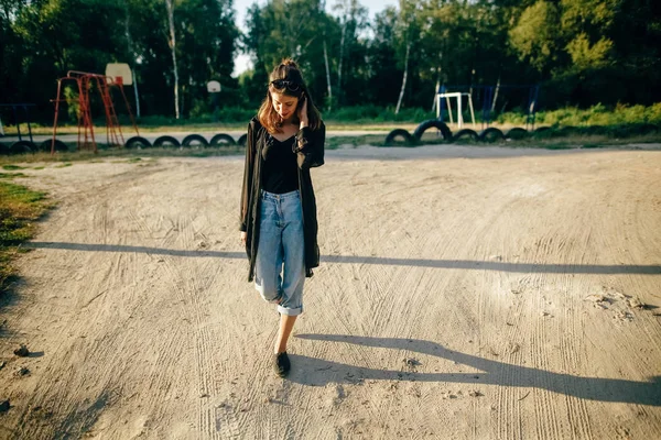 Stylish hipster girl walking in sunny street, atmospheric moment — Stock Photo, Image