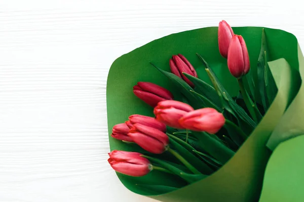 Piękne różowe tulipany bukiet w zielonej księdze na białym drewnianym BAC — Zdjęcie stockowe