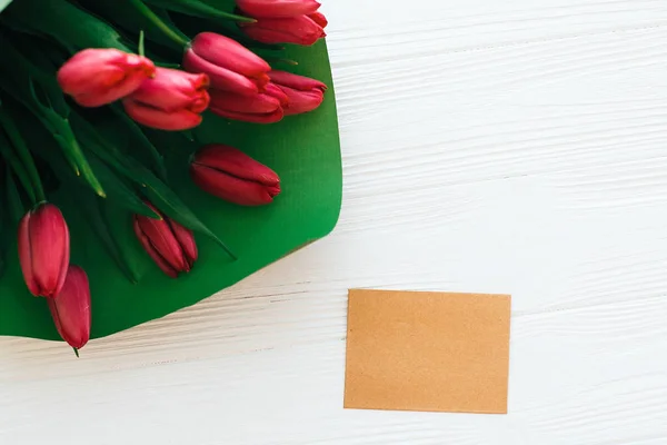Красивий букет з червоних тюльпанів в зеленому папері і ремісничої картки з — стокове фото