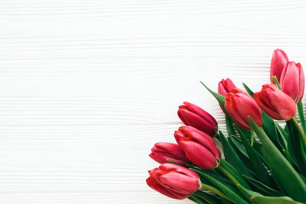 Překrásné Rudé tulipány na bílém dřevěném pozadí ve světle. Veselé — Stock fotografie