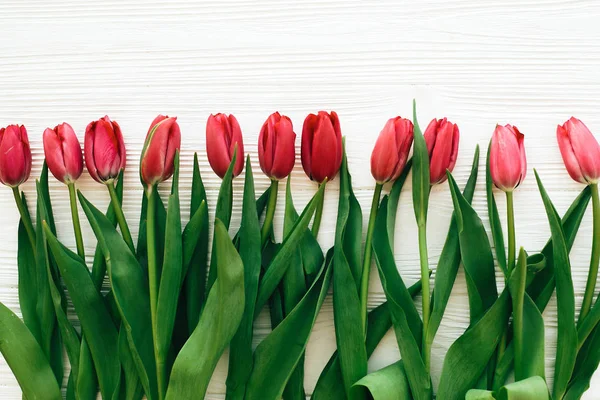 Olá conceito primavera. Tulipas vermelhas bonitas na parte traseira de madeira branca — Fotografia de Stock