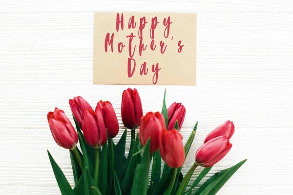 Happy Mother's Day text and beautiful red tulips on white wooden — Stock Photo, Image