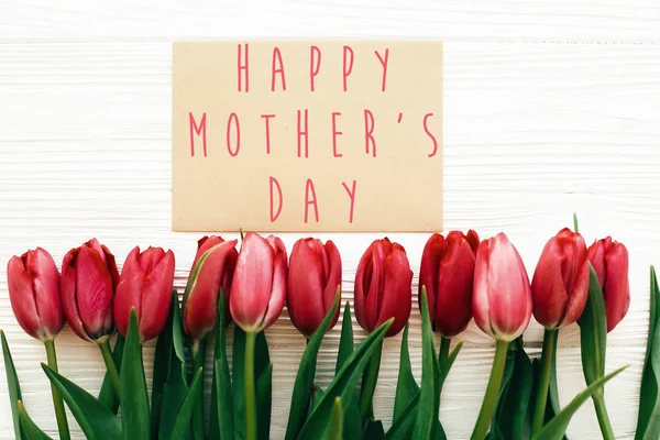 Happy Mother's Day tekst en mooie rode tulpen op witte houten — Stockfoto