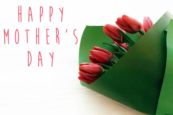 Happy Mother's Day tekst en mooie rode tulpen op witte houten — Stockfoto