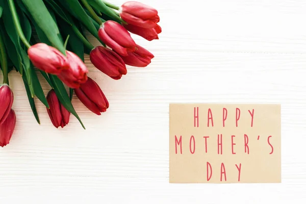 Happy Mother's Day tekst en mooie rode tulpen op witte houten — Stockfoto