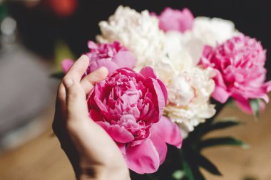 El cam j güzel pembe ve beyaz şakayık buketi tutan