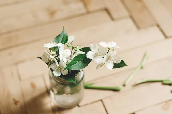 Piękne kwiaty jaśminu na gałęzi w szklanym słoiku na rustykalny stary w — Zdjęcie stockowe