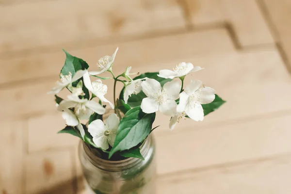 Hermosas flores de jazmín en la rama en frasco de vidrio en rústico w edad — Foto de Stock