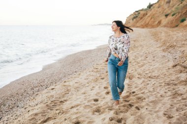 Şık hipster kız denizde sahilde yürüyüş ve rahatlatıcı. Mutlu