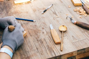 Tahta atölyesi. Eller tahtadan kaşık oyuyor, chi ile çalışıyor.