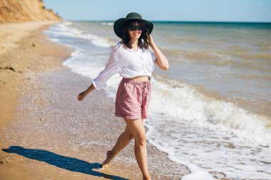 Yaz tatili. Mutlu genç boho kadın deniz dalgaları içinde yürüyüş 