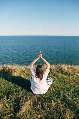 Şık hipster kız oturan ve dağ tepe zekâ yoga yapıyor