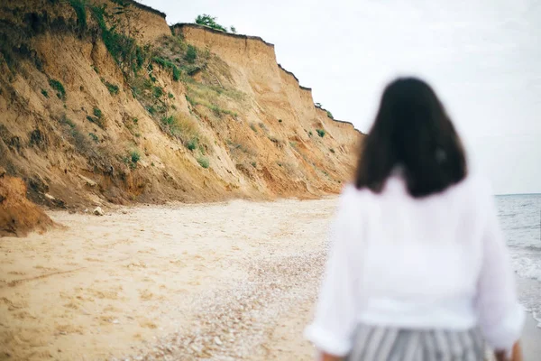 Areia penhasco e praia perto do mar e imagem borrada de menina hipster — Fotografia de Stock