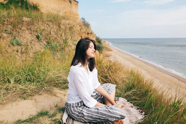 Menina elegante hipster sentado na praia e fazendo ioga. Boho feliz — Fotografia de Stock