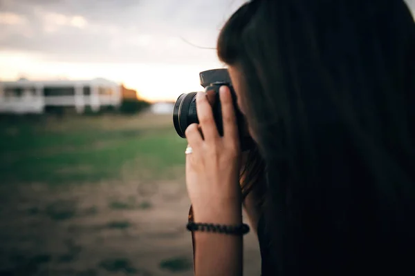 Elegante ragazza hipster scattare foto sulla spiaggia al tramonto. Estate va — Foto Stock