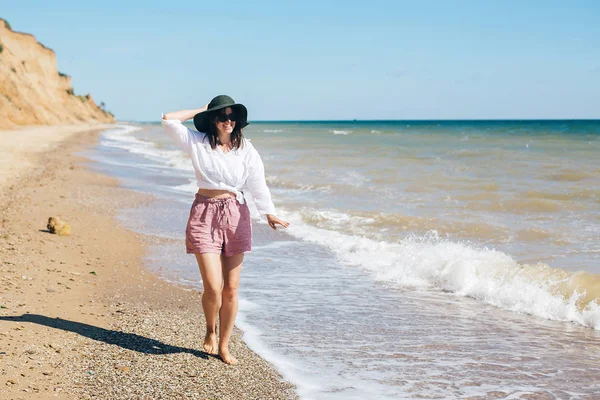 Glückliche junge Boho-Frau, die an sonnigen, warmen Tagen in Meereswellen wandelt — Stockfoto