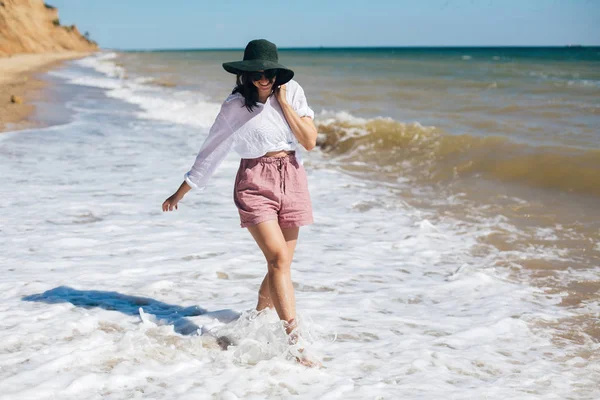 Glückliche junge Boho-Frau, die an sonnigen, warmen Tagen in Meereswellen wandelt — Stockfoto