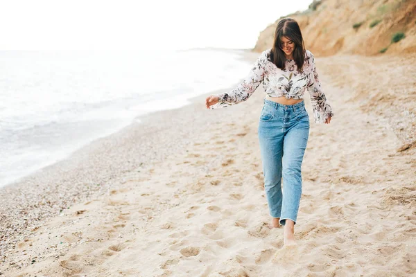 Stylisches Hipster-Mädchen, das am Strand auf See läuft und lächelt. glücklich — Stockfoto