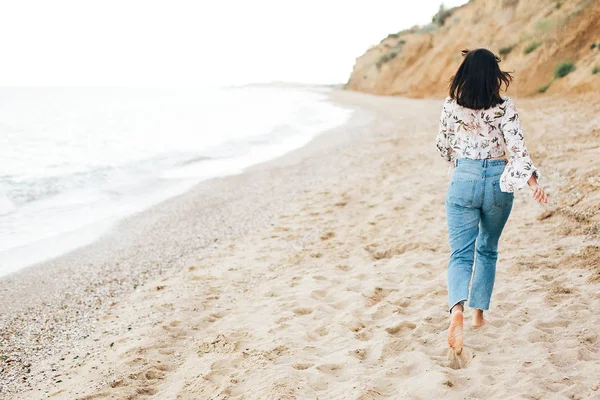 Stylisches Hipster-Mädchen läuft barfuß am Strand am Meer, zurück vie — Stockfoto