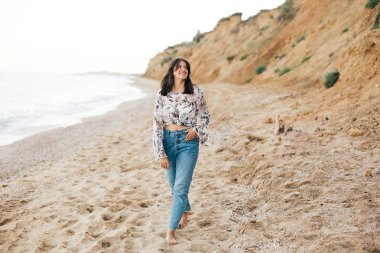 Şık hipster kız denizde sahilde yürüyüş ve rahatlatıcı. Mutlu