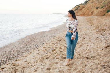 Şık hipster kız denizde sahilde yürüyüş ve rahatlatıcı. Mutlu