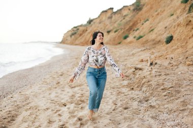 Şık hipster kız denizde sahilde çalışan ve gülümseyerek. Mutlu 