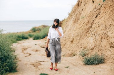 Plajda rahatlatıcı şık hipster kız. Mutlu genç boho kadın 