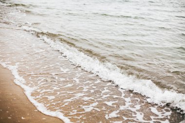 Güzel deniz dalgaları köpük closeup ve deniz kabukları ile kumlu plaj 