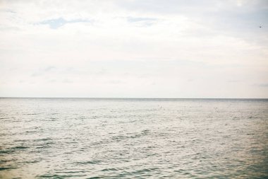 Tropik islan bulutlar ile güzel sakin deniz yüzeyi ve gökyüzü